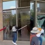 Encapuchados rompen cristales de la Torre del Bienestar durante protesta de la CNTE